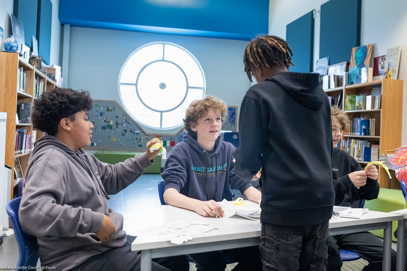 Students trade items with one another, creating a hustle and bustle of tables resembling a marketplace.