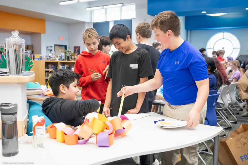 Students trade items with one another, creating a hustle and bustle of tables resembling a marketplace.
