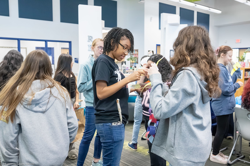Students trade items with one another, creating a hustle and bustle of tables resembling a marketplace.