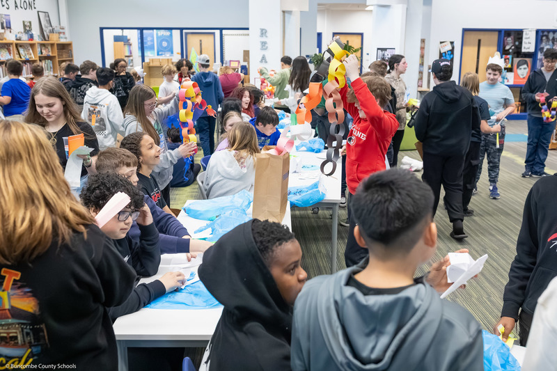 Students trade items with one another, creating a hustle and bustle of tables resembling a marketplace.
