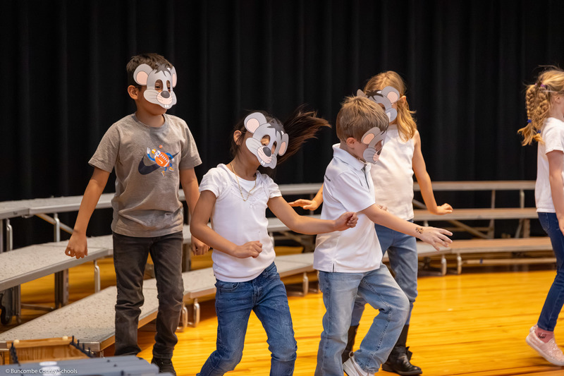 Four students dance while wearing mouse masks.