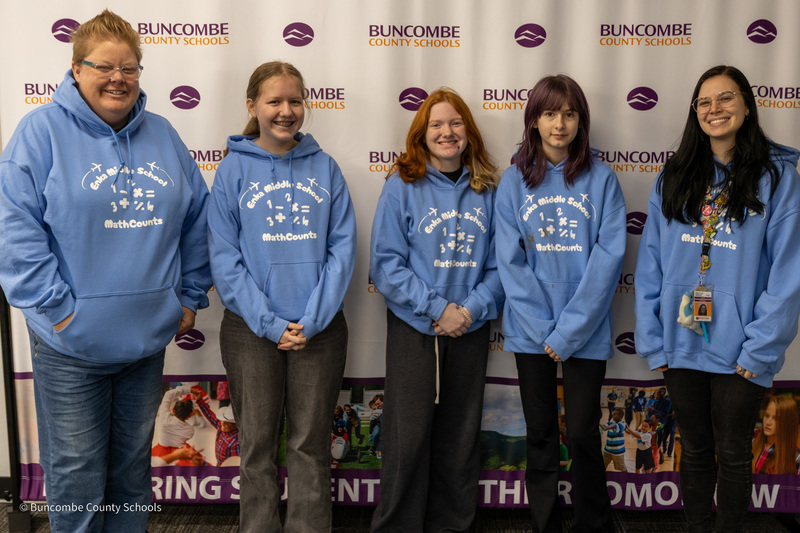 The Enka Middle School MathCounts team poses in front of the BCS banner.