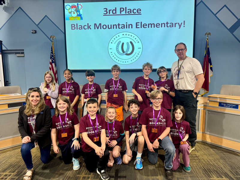 The third place Black Mountain Elementary team poses in front of a congratulatory screen.