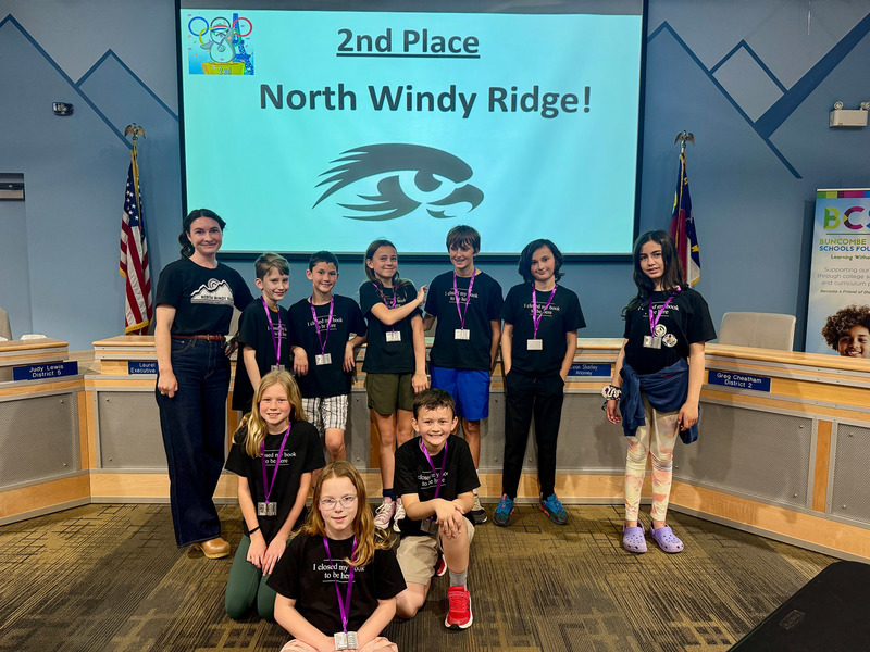 The second place North Windy Ridge Intermediate team poses in front of a congratulatory screen.