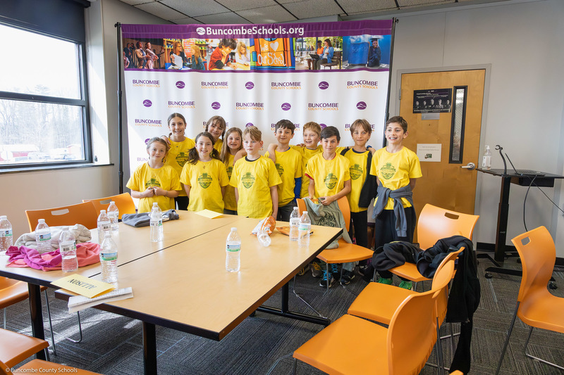 The Haw Creek Elementary team poses in front of a Buncombe County Schools background.
