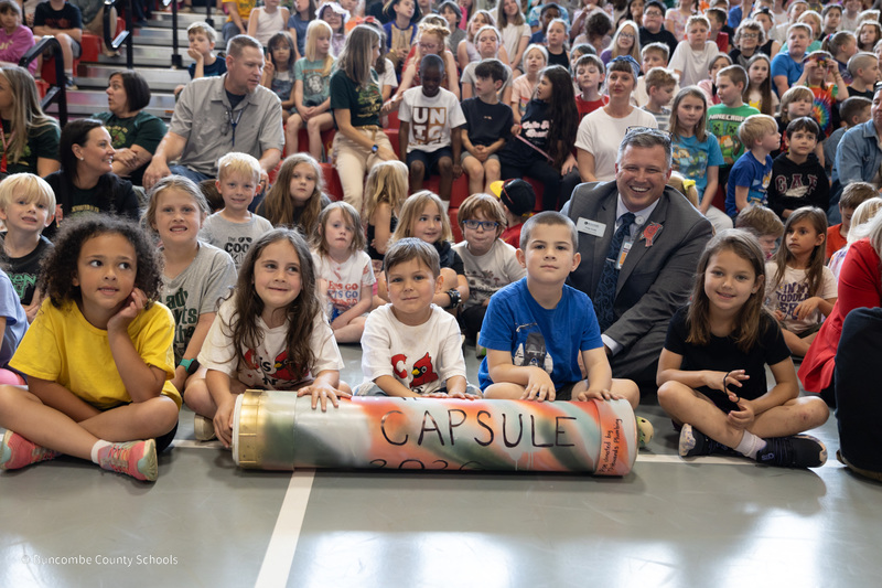 Students sit with Mr. Cody and the time capsule