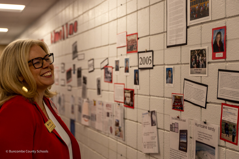 Dr. Reed looks at a photo collage that includes her photo during her first year as principal