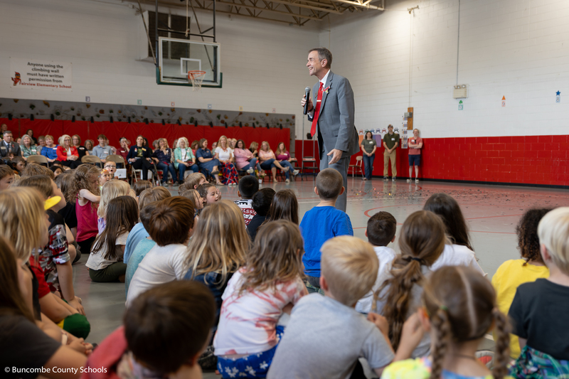Dr. Jackson holds a microphone addressing students