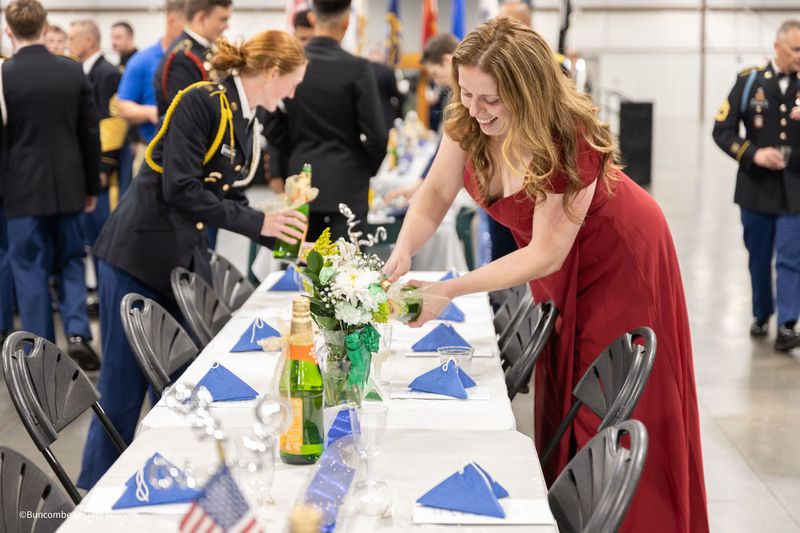 Cadets and Instructors filling glasses on tables with grape juice