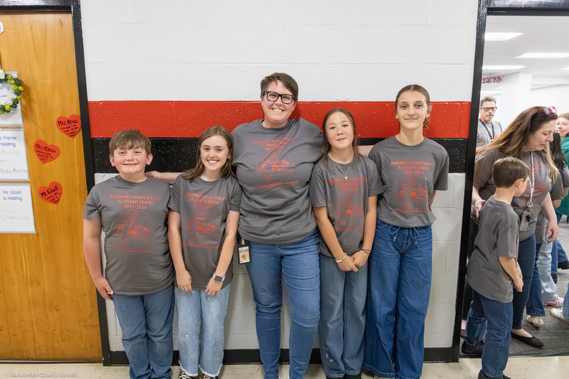 Four students pose in a hallway with a teacher.