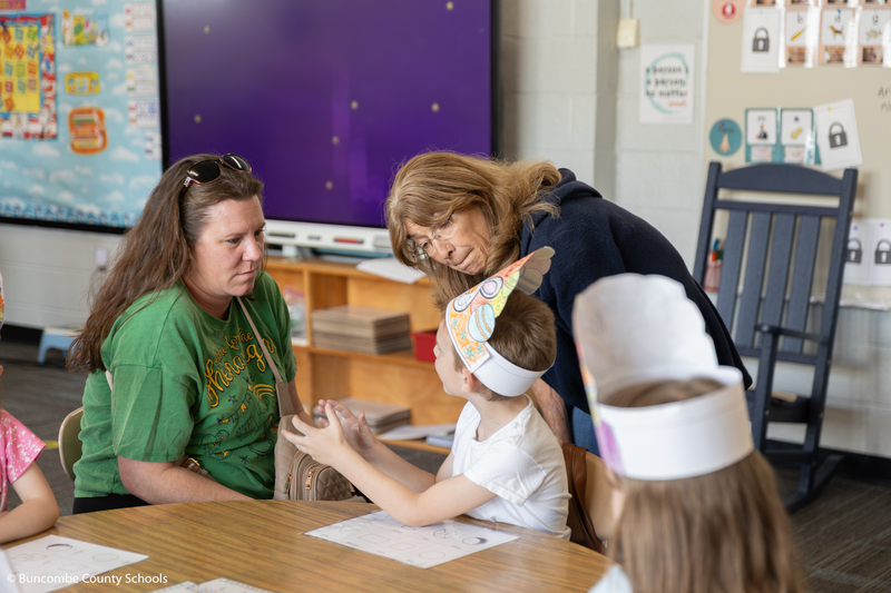 Grandmother and mom listening to what their child is saying. 
