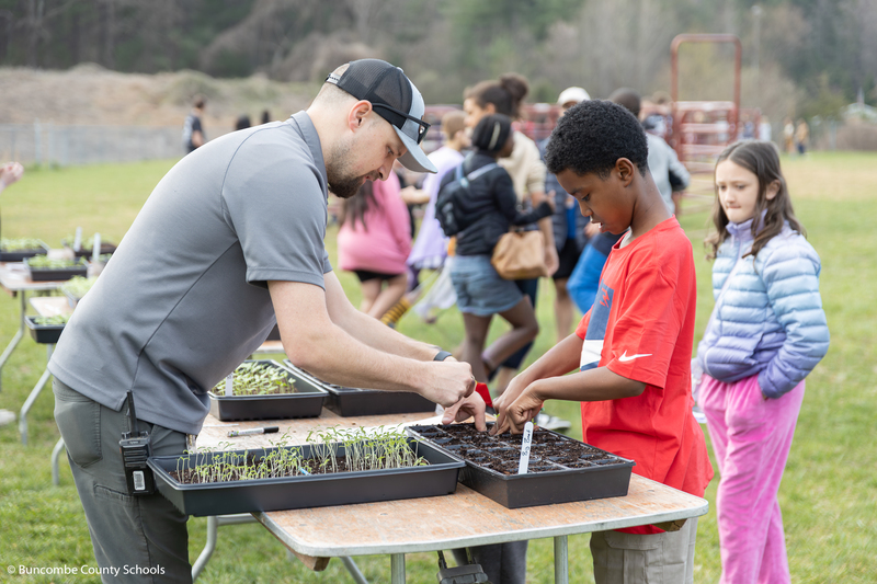Fifth grade student planting seed with Horticulture teach Adam Byrd. 