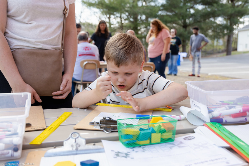 A student concentrates on a project at one of the science tables.