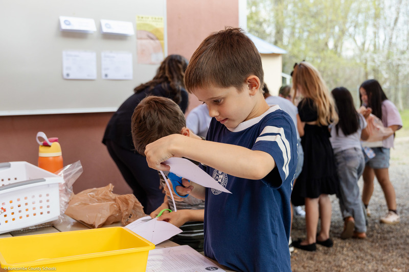 A student makes a shape out of paper.