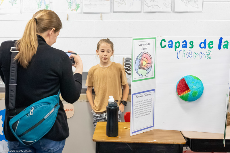 A girl speaks to a woman about her presentation.