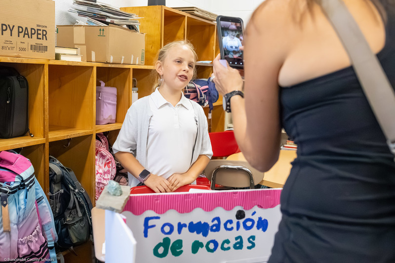 A girl speaks to a woman about her presentation.