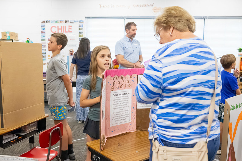 A girl speaks to a woman about her presentation.