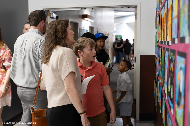 Mother and son looking at artwork on the wall. 