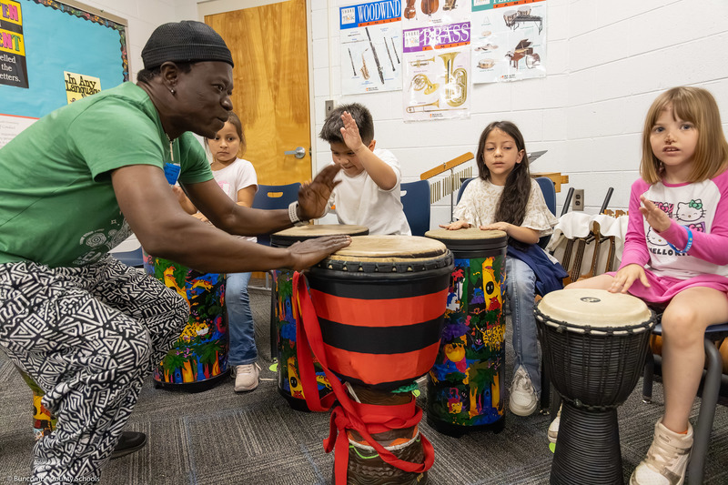 Adam Dembele leads a class through a hand drum routine in Preston Prince's music class.