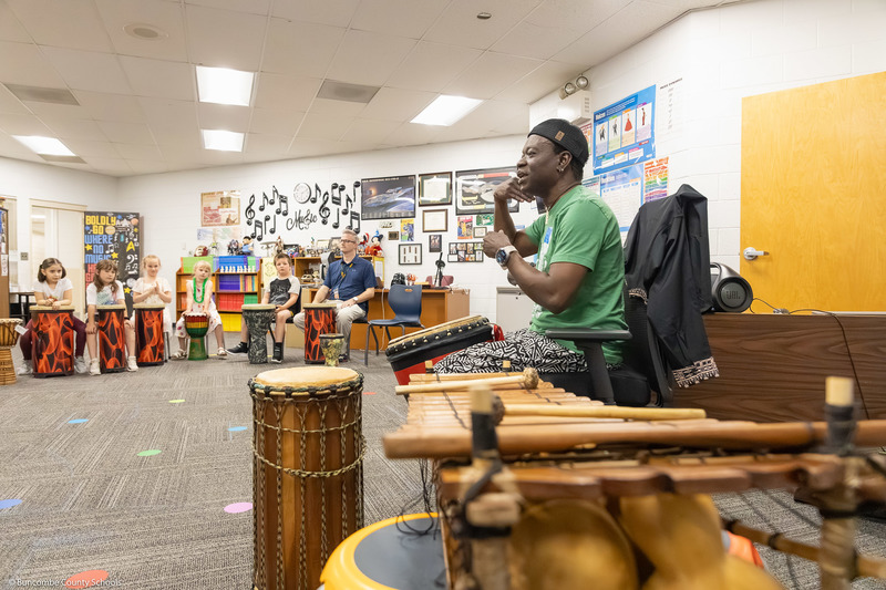 Adam Dembele leads a class through a hand drum routine in Preston Prince's music class.