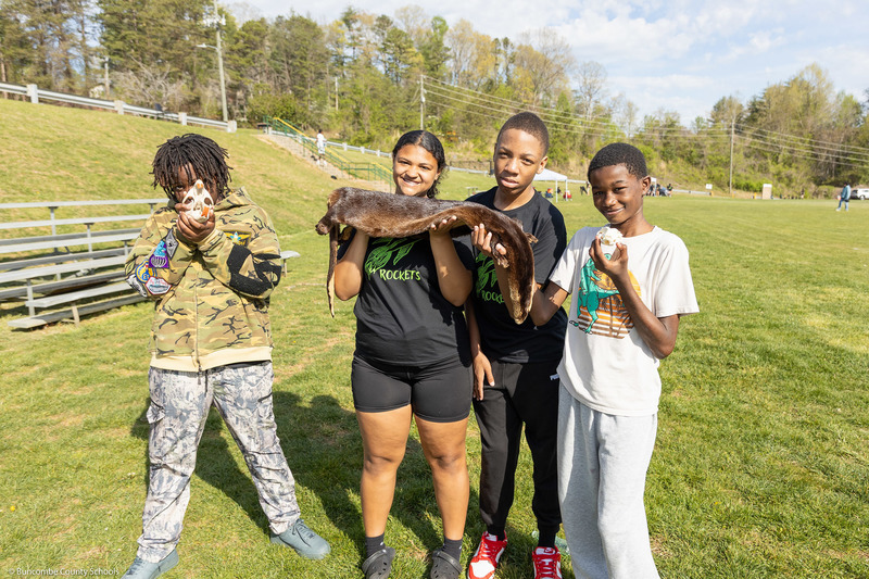 Four students pose with pelts and skulls from WNC Nature Center.