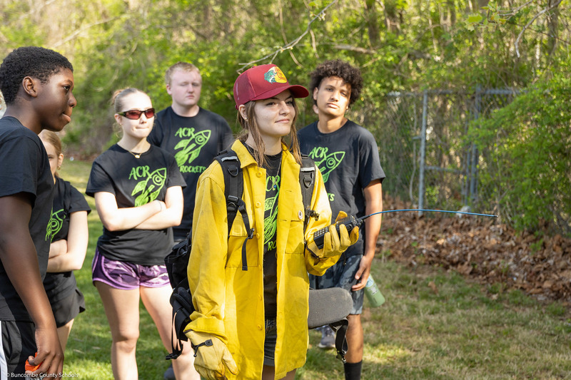 A student smiles while wearing turnout gear for fighting wildland fires.