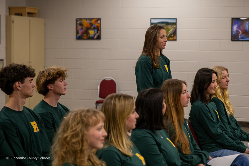 Ms. Brouwer stands among her students seated in a Policy Committee meeting.