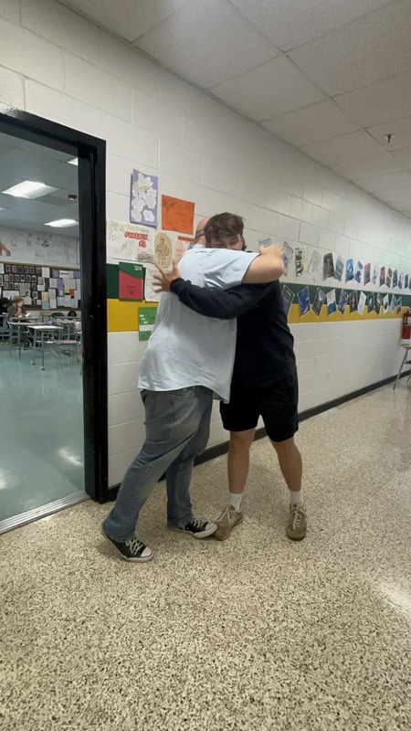 Baseball senior hugging a teacher. 