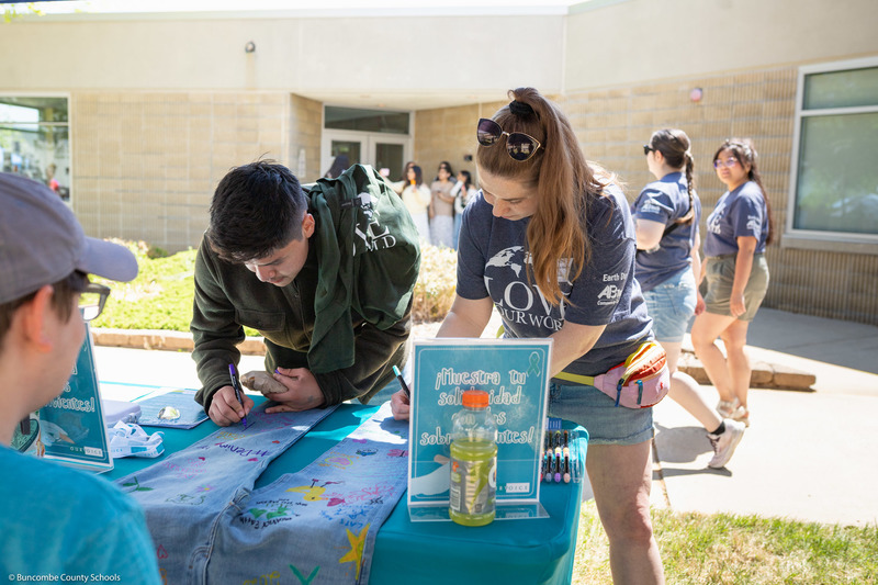 Two student speak with an outdoors presenter.
