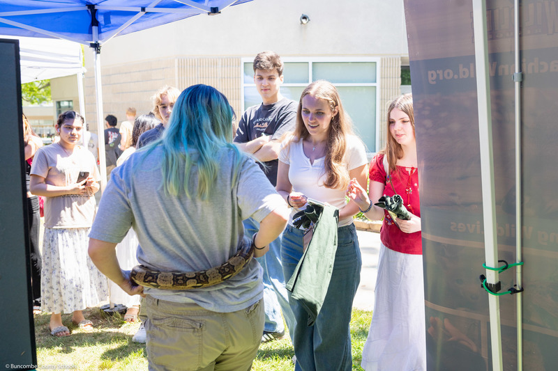 Three students speak with an outdoors presenter.