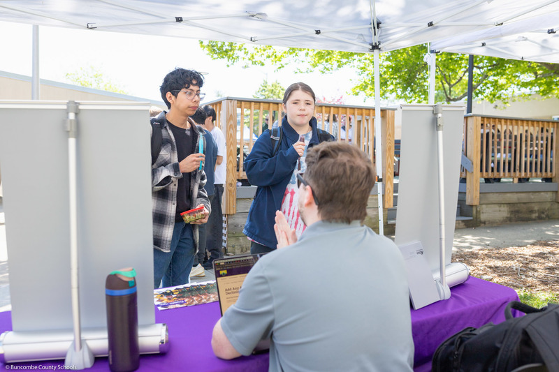 Two student speak with an outdoors presenter.