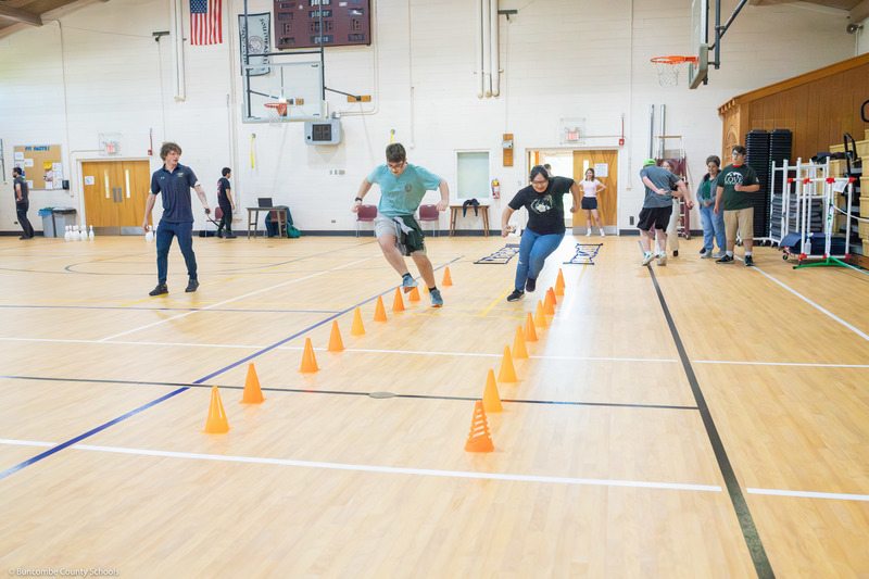 Two students run on an obstacle course.