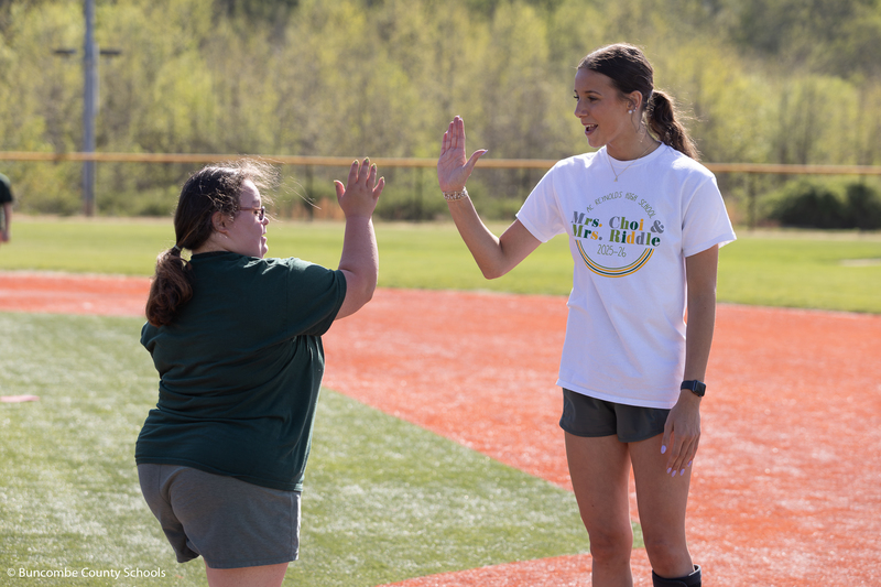 Two students giving each other a high five. 
