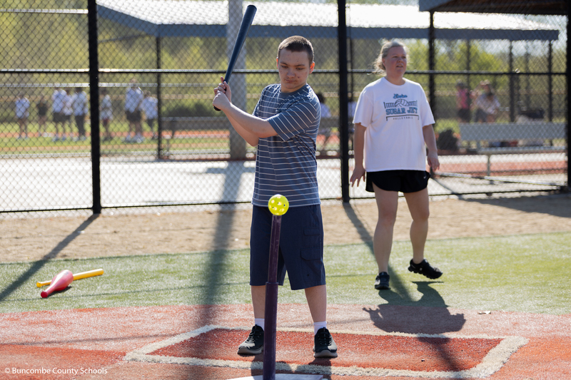 Student hitting a ball with a bat.