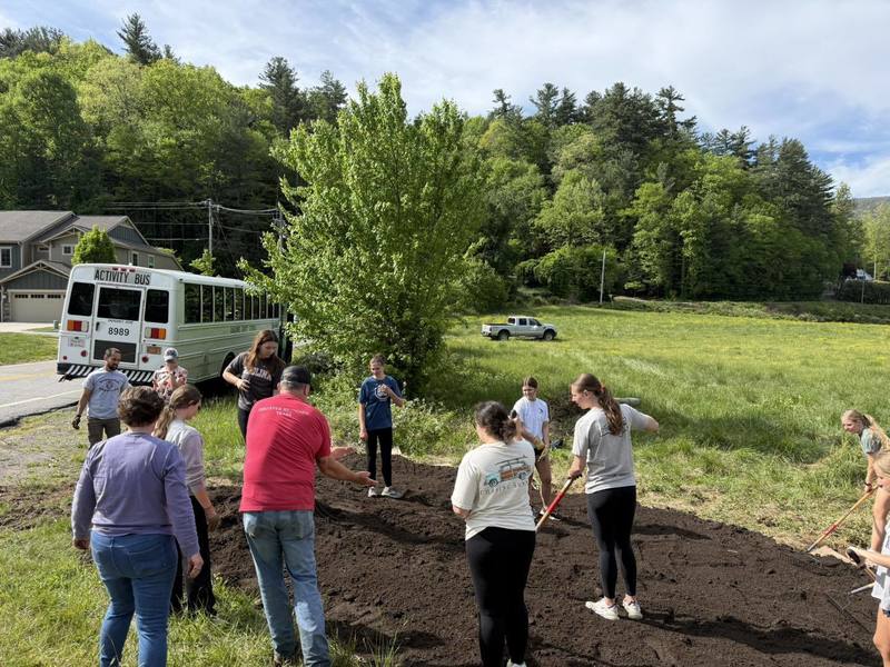 Students use rakes and hands to pick up littler.