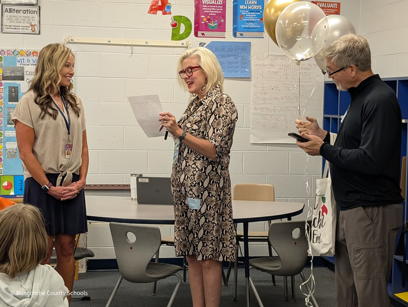 Melanie from Mix 96.5 holds a letter that she is reading to Ms. Atkinson.