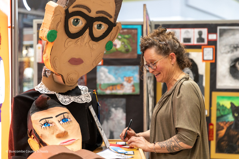 An art teacher looks at paper mache sculpture