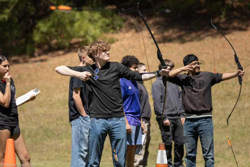A student aims at the target.