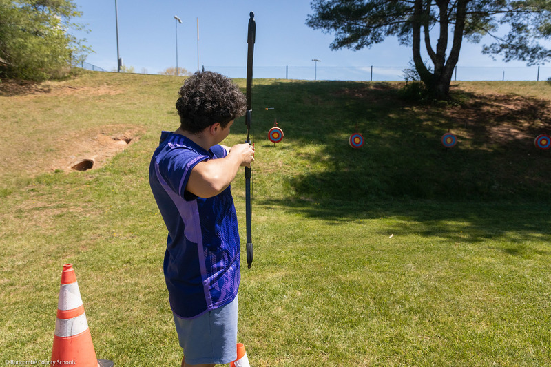 A student aims at the target.