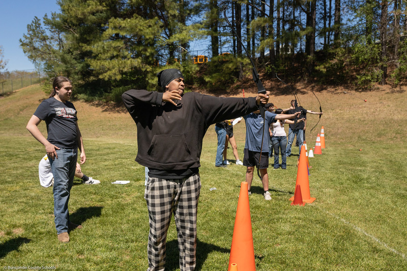 A student aims at the target.