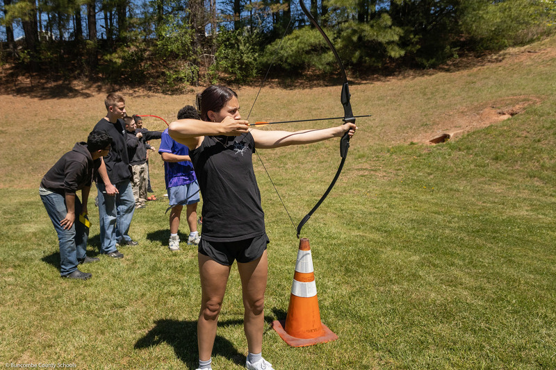 A student aims at the target.