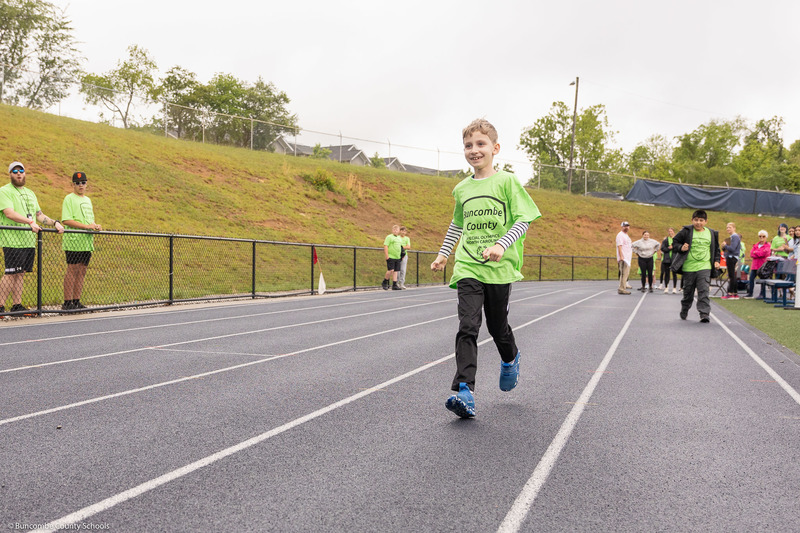 Student running across the finish line. 