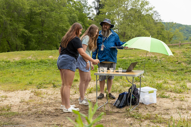 Two students test samples as Mr. Bell instructs them.