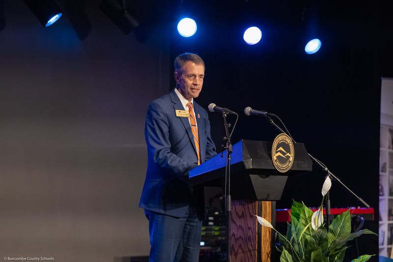 Dr. Jackson stands on stage behind a BCS podium addressing the audience.