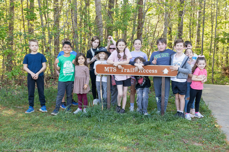 Virtual Academy students pose behind a Mountains to Sea Trail sign.