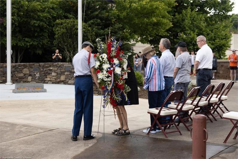 A ROTC member placing a floral arrangement during a ceremony