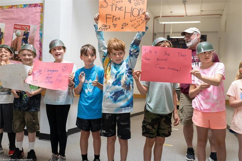 Young students holding handmade signs lined up in the hall Young students holding handmade signs lined up in the hall