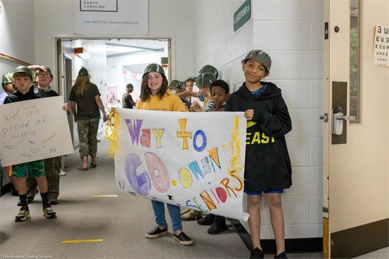 Upper elementary holding handmade signs in the hall Upper elementary holding handmade signs in the hall