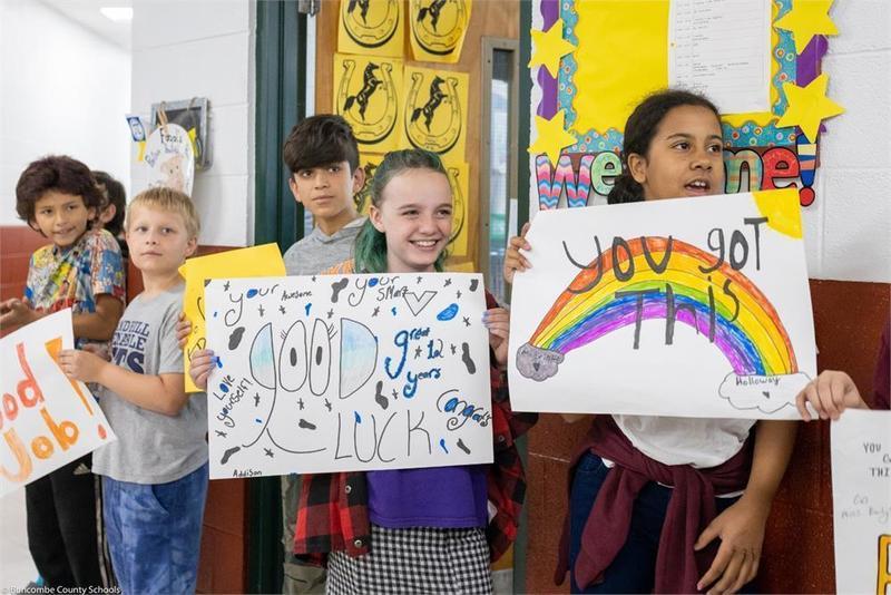Students holding handmade signs in the hall Students holding handmade signs in the hall