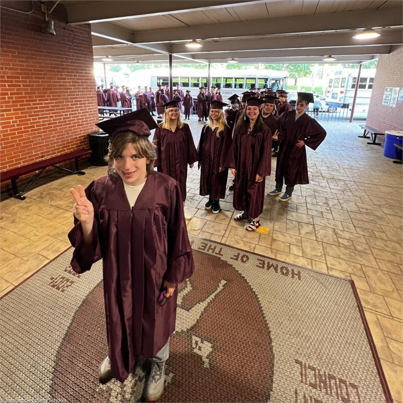 Graduates walking off the bus and into the school Graduates walking off the bus and into the school